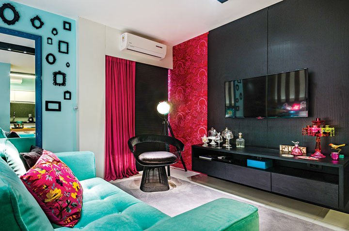 O pink na cortina de linho e no papel de parede de veludo (Villa Cores) faz contraponto à persiana e ao móvel planejado preto, desenhado para acomodar a TV. 
