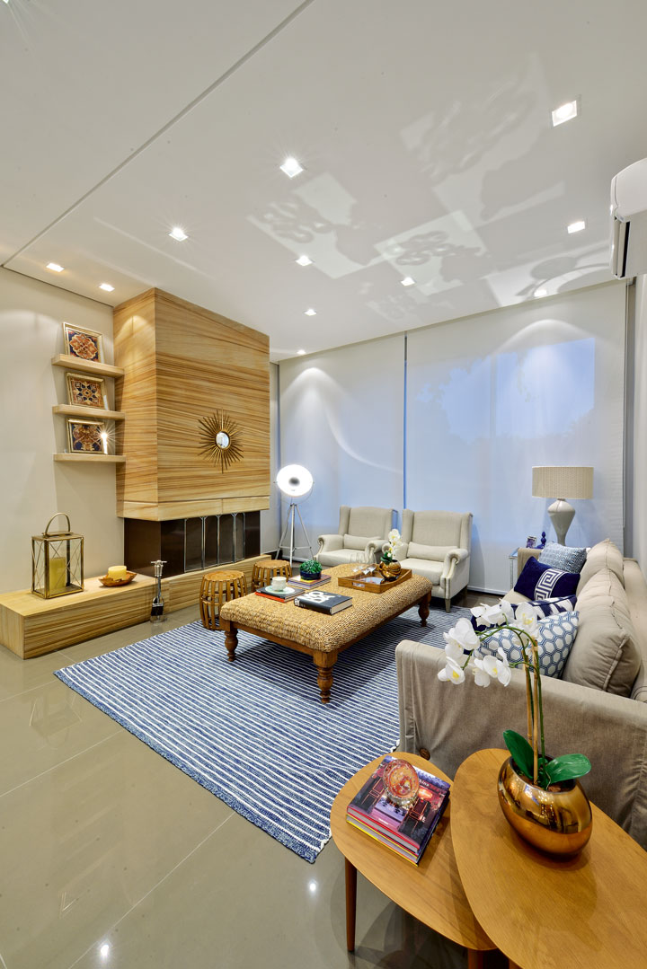 Tons de azul e fibras naturais imprimem aconchego à sala que abriga a lareira revestida com Limestone Teakwood (Geraldini Mármores e Granitos). As persianas são Sunsoft e o sofá é da Francesco Estofados