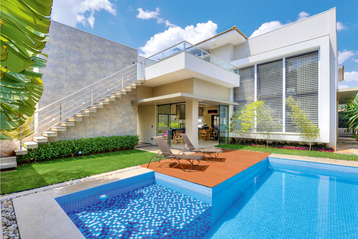 Junto à piscina, o deck de madeira (Frascareli) com espreguiçadeiras convida aos banhos de sol