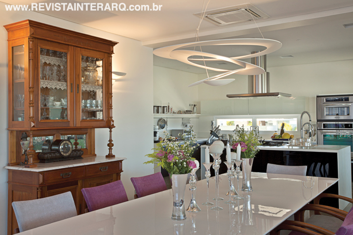 A decoração respeitou a personalidade dos moradores e preservou muito da história de vida deles, trazendo para o contexto peças de mobiliário que eram da família há muitos anos, como a cristaleira da sala de jantar, que foi restaurada e usada ao lado da mesa em laca branca e das luminárias contemporâneas. 