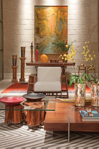 O living com espelho d’água foi “vestido” com tapetes estampados (Gallery Tapetes), móveis em fibras naturais e madeira (Quadra Design e Artefacto). 