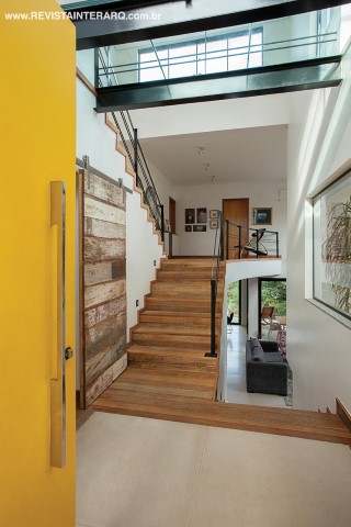 O hall de entrada proporciona uma visão privilegiada dos três níveis da casa. Subindo os degraus há um mezanino de distribuição para os quartos do casal, dos dois filhos e o da filha, que fica um patamar acima. 