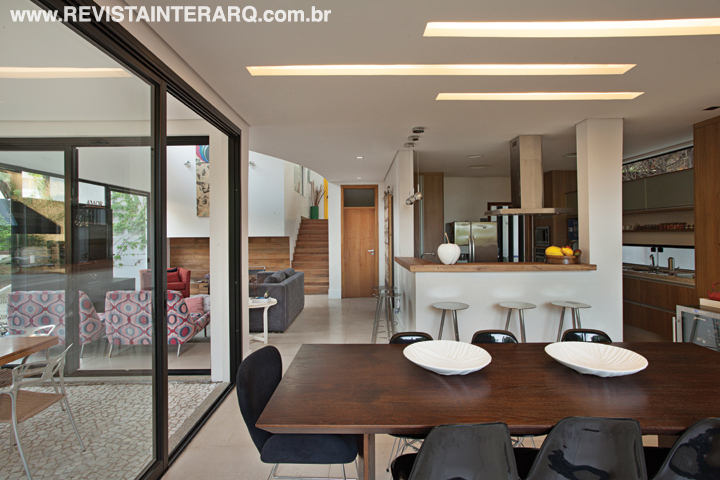 O projeto luminotécnico é pontual, com luzes balizadoras na escada, arandelas de luz indireta, spots de iluminação teatral e embutidos. Na área da cozinha, sala de estar, espaço gourmet e jantar o convívio familiar foi privilegiado pela unidade visual. Os móveis planejados são da Carvalho Madeiras. 