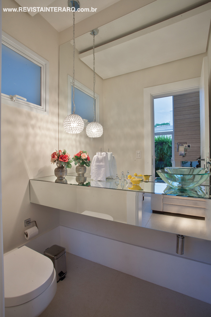 A bancada espelhada com cuba de vidro conferiu sensação de amplitude ao lavabo