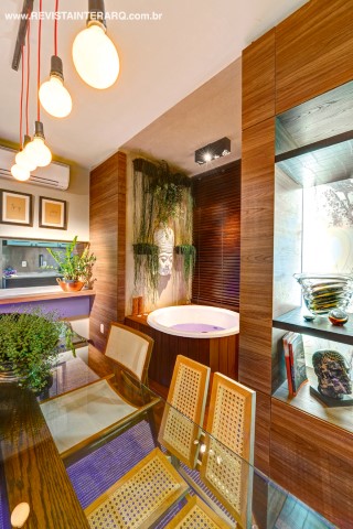 No lado oposto do living foi posicionado um painel de madeira com nichos e gavetas (Wood Design), que reveste toda a parede e emoldura o Spa e deck (Frascareli)