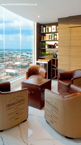 O ponto-chave do projeto foi a integração total do segundo piso da cobertura, com vista 180º de toda a cidade. O visual incrível inspirou a criação de um bar com marcenaria planejada (Dell Anno) e um pequeno estar com poltronas de couro e baú como mesa de centro, ao lado do pano de vidro (Vidral)