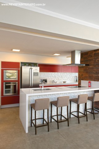 O espaço gourmet surpreende com os armários em gofrato vinho (Decora Móveis) e revestimento branco da Bisazza, mesmo tom da bancada em Caesarstone 