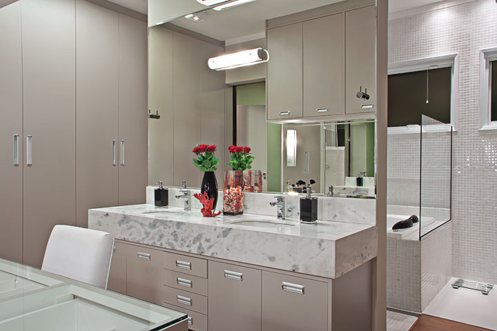 Um closet com móvel para make e bancada em mármore branco (Marmoraria São Jorge) forma uma antessala para a área de banho. O Spa é a Riolax