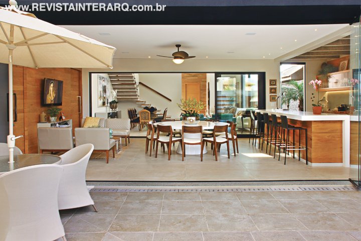 Integrada ao social, a varanda gourmet, recebe os convidados com conforto e beleza. A mesa circular em laca branca acomoda 10 cadeiras assinadas pelo designer Aristeu Pires (tudo da Jackie Móveis). O espaço conta ainda com estar com estofados, mesa de centro (Perfil Casa) e bancada em Caesarstone (Marmoraria São Jorge). Iluminação da MM Iluminação