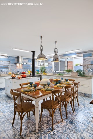 A vocação do lugar e o gosto da família para receber amigos para confraternizações e festas de todos os portes inspirou a ampliação da cozinha, que dobrou de tamanho e ganhou uma atmosfera campestre com os porcelanatos com estampas de azulejaria portuguesa (Casa dos Construtores), fogão a lenha e pendentes (Casa Luz) sobre a mesa e cadeiras de madeira (P.O. Estofados)