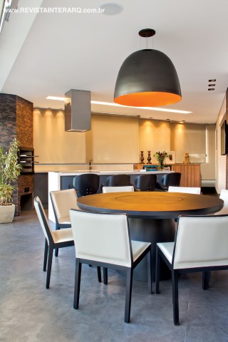 A luminária preta e laranja (Iluminare) é um dos destaques da área gourmet, com piso em porcelanato cinza e mosaico da Palimanan na parede da churrasqueira (ambos da Toque Final)