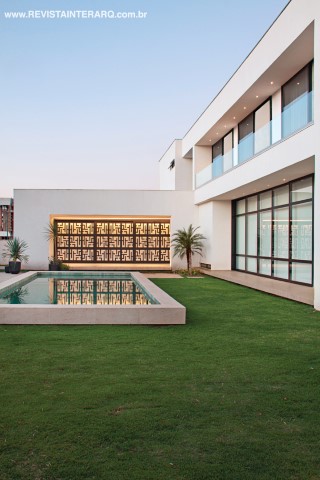 O lazer surpreende com o portão desenhado pelo arquiteto e pela piscina revestida com pedras Hijau, da Palimanan (Toque Final) e com borda em mármore Travertino Romano (Alfa Marmoraria). As esquadrias pretas são da Nova Alumiglass