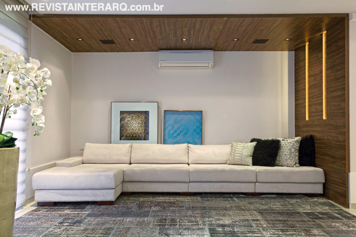 Um sofá feito sob medida em ultra-suede fendi ocupa toda a parede do home theater, que tem ainda poltronas giratórias, nichos no painel em laca branca da TV e uma acolhedora iluminação embutida