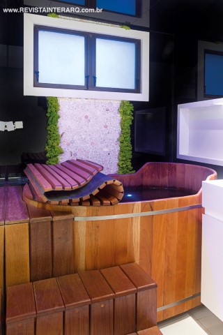 O projeto acrescentou um ofurô ao banho do casal e uma parede de pastilhas circulares e musgo sintético