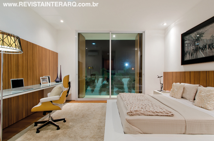 O móvel planejado de linhas retas (Marcato) forma um pequeno office na suíte com piso de Peroba (Ateliê Revestimentos Roberto Cervellini). O tapete cru é da Harba e a iluminação, da ViaLight