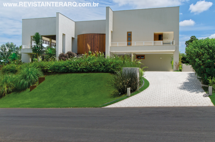 A arquitetura da fachada tirou partido do declive do terreno, criando diversos mirantes para contemplar ora o campo de golfe, ora a área verde do condomínio. O paisagismo de Pedro Garcia Lopes e João Jadão acompanha a proposta e desenha a entrada de carros, revestida com piso industrial da Gail