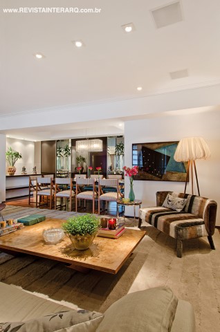 Onde havia uma lareira, o arquiteto instalou um apoio para a mesa de jantar que parece flutuar graças à ausência de pés. A obra de arte é de Atrhur Luiz Piza e a luminária tem assinatura de Baba Vacaro. O armário louceiro com portas deslizantes e nichos espelhados é da S.C.A