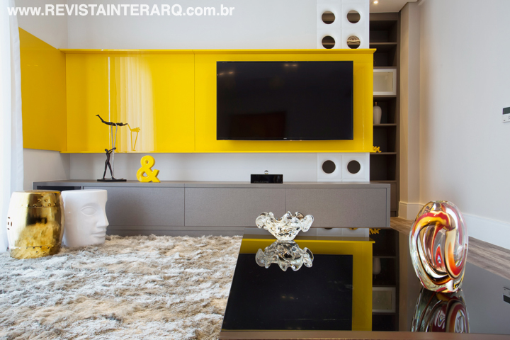 O home theater apresenta uma interessante composição em preto, cinza e amarelo, que ressalta o móvel da TV