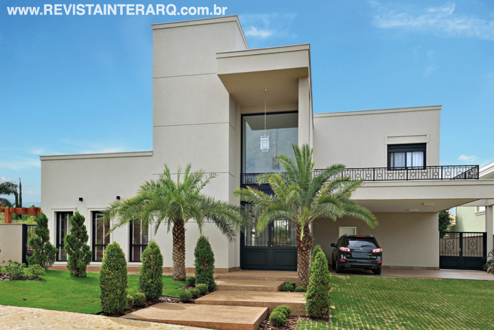 A nova leitura da fachada conferiu mais sobriedade com a textura fendi e gradis pretos trabalhados. A porta em ferro e vidro permite admirar o belo lustre no interior 