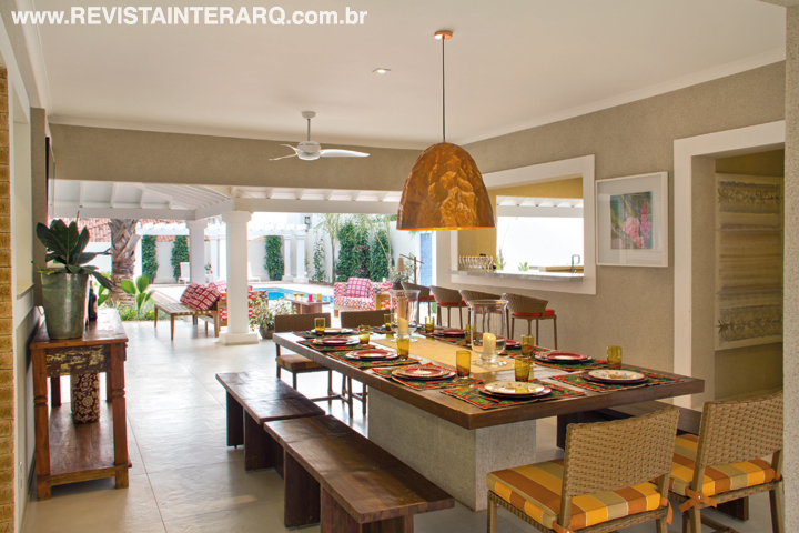 A área gourmet tem um ar festivo, conferido pelo lustre de cobre, móveis de madeira e fibra (Brasil Post) e textura nas paredes. O piso é da Florim Revestimentos e os quadros, da Artgesso São Francisco