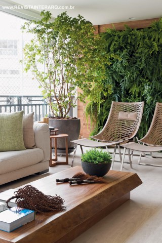 O amplo terraço foi totalmente integrado ao living, permitindo abundância da luz natural nos ambientes. Um jardim vertical foi criado em uma das paredes dando mais acolhimento e a sensação de se estar quase em uma casa