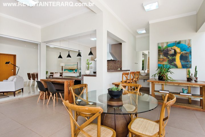 Na área gourmet, o aparador em madeira de demolição compõe com as cadeiras da Espaço Moderno e com o tom do mármore Marrom Absoluto. Armários da Dell Anno, coifa em inox da Coifas e Coifas e luminárias da Living Lustres