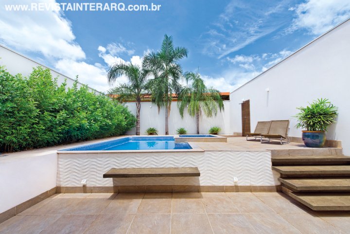 O desnível do terreno permitiu elevar a piscina (Center Piscinas) e o jardim