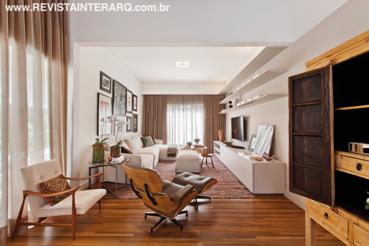 O estar foi “vestido” com cortinas de seda e ganhou peças de design, como a poltrona Charles Eames e o Banco Mocho, de Sérgio Rodrigues