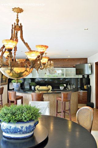 A varanda, se divide em área gourmet, com churrasqueira e mesa de refeições sob o lustre de alabastro encontrado em um antiquário, e um estar acolhedor, com mobiliário em fibra natural e almofadas em linho puro