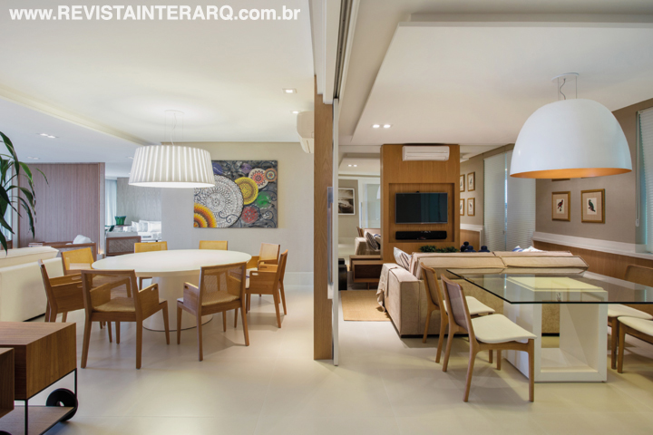 Da saleta de almoço, ambientada com mesa com tampo de vidro, cadeiras Jader Almeida (Marcia Silveira Ambientações) e pendente em alumínio (Kelvin LD), é possível acompanhar o movimento no aconchegante home theater com sofá em suede