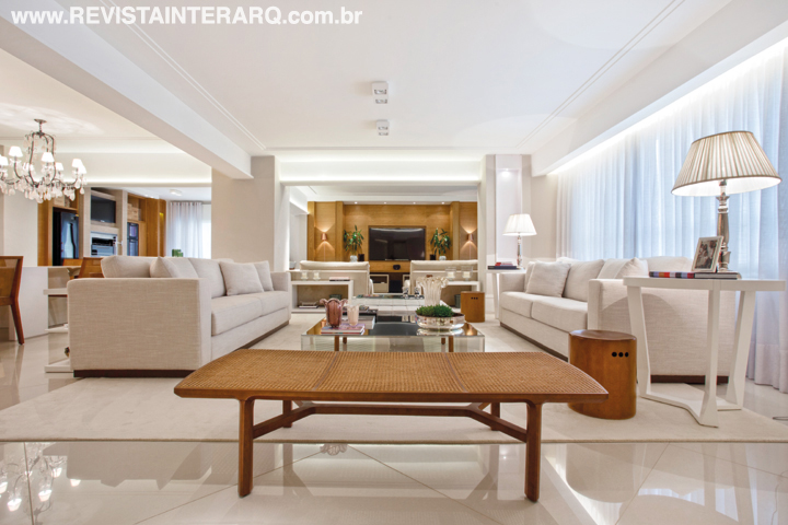 O piso em porcelanato polido claro (Atelier Portinari) foi a escolha para todo o social e, somado às molduras de gesso (Gessoteto) e às cortinas em gaze de linho (Délicatesse Tecidos), cria um cenário clean, arrematado pelos Muranos (Bandeirantes Casa), estofados em linho e tapete de lã (tudo da Marcia Silveira Ambientações). Ao fundo, luminárias de piso em cobre da Kelvin LD