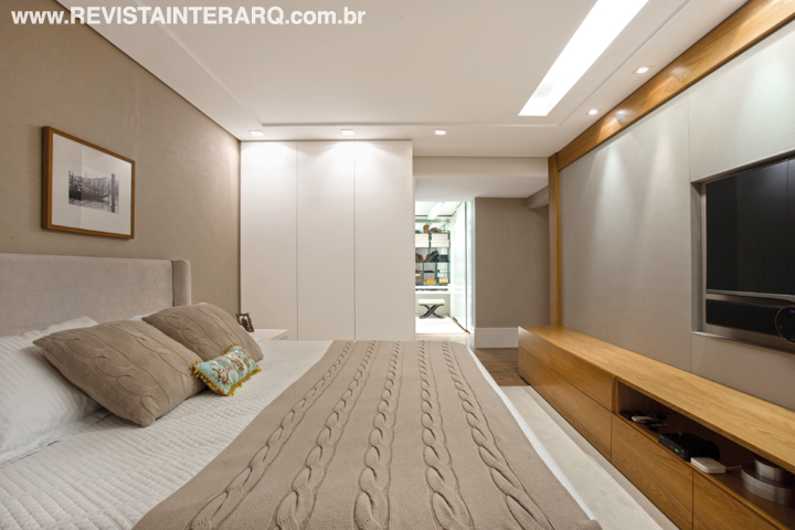 A sanca de gesso (Gessoteto) com iluminação indireta traz conforto e suavidade ao quarto do casal. A sofisticação ficou por conta das paredes revestidas em papel claro (Délicatesse Tecidos) e painel com acabamento em lona pespontada (Le Cadeau Curtume Casa). Enxoval da Bandeirantes Casa. TV e equipamentos da Digital Home