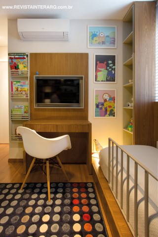 A marcenaria em madeira freijó (Móveis RM) e laca cinza é acolhedora e forma uma base neutra para todos os brinquedos, quadros e tapete colorido. TV da Digital Home