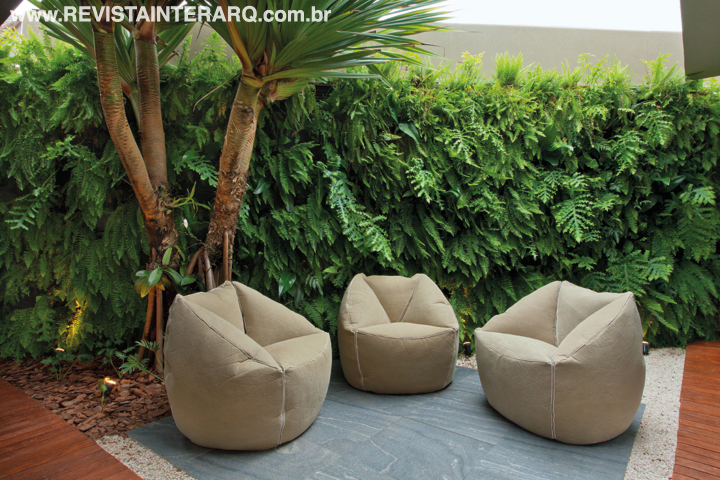 O jardim vertical trocou o muro por uma vista exuberante, que pode ser contemplada das confortáveis poltronas Mexerica, do Estudiobola, no espaço de relax da equipe