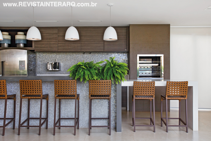A bancada gourmet tem tampo em Silestone (Marmoraria Gran-Norte) e revestimento em pastilhas de vidro (Portobello Shop). O porcelanato da Portobello Shop acompanha o tom dos armários planejados (incomap Móveis). A limpeza final da obra foi feita pela Acqualimp