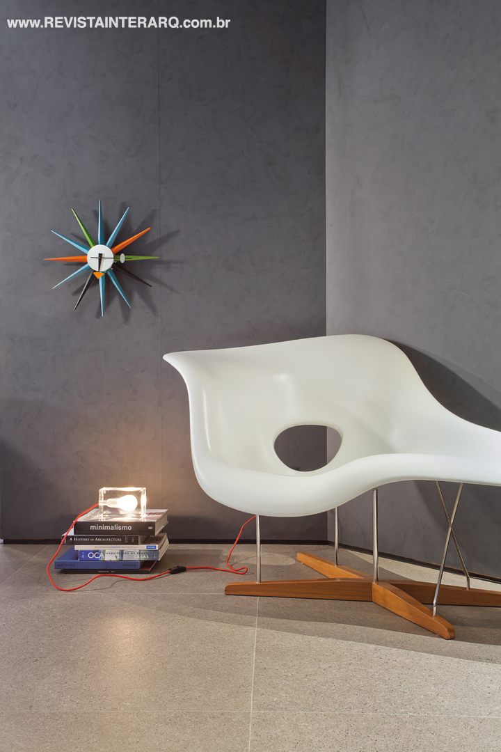 A poltrona La Chaise, desenhada em 1948 por Charles e Ray Eames, e o colorido relógio Sunburst, assinado por George Nelson