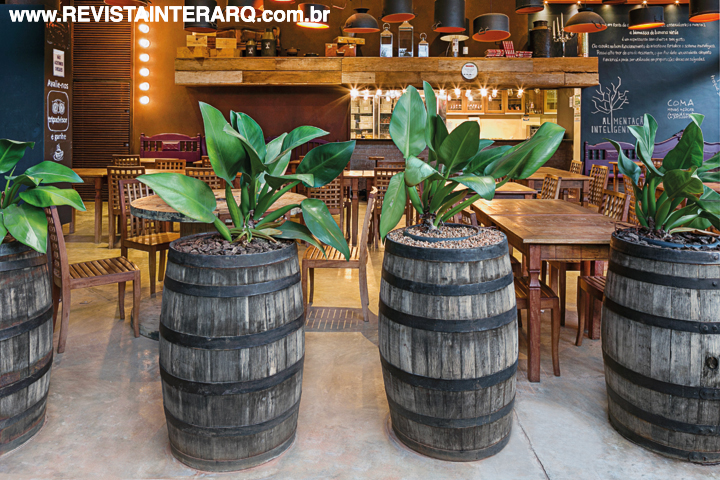 Barris de madeira funcionam como cachepôs, imprimindo rusticidade. Toda a estrutura do restaurante ganhou pintura texturizada Corten Terracor, da Dom Gabriel