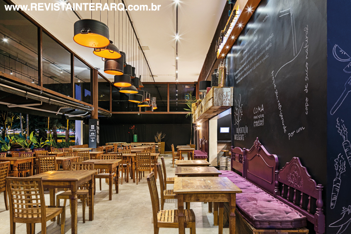 Cabeceiras antigas receberam pintura berinjela para compor os bancos. A iluminação foi executada com panelas de alumínio com pintura preta e abóbora