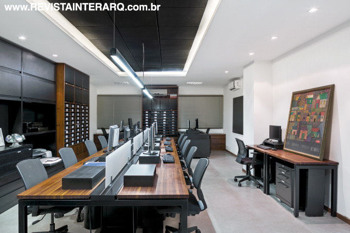 O moderno operacional mescla bancadas de trabalho em Teca natural com móveis planejados pretos (Lovath Móveis). As persianas dos três ambientes são da Luxaflex – Hunter Douglas (Finestri)