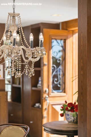 Lustre, mesa, cadeiras e portas remetem ao estilo francês