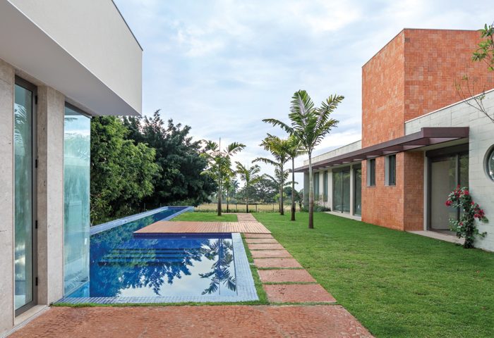 O terreno de medidas generosas permitiu a criação de um quadro verde através de uma cerca viva de Ficus na fachada da casa - Revista InterArq | Arquitetura, Decoração, Design, Paisagismo e Lifestyle