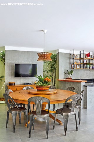 A mesa de madeira com tampo giratório compõe com cadeiras de ferro. Porcelanato da Casa dos Construtores. O projeto de arquitetura original é de Germana Zanetti e Leandro Madi