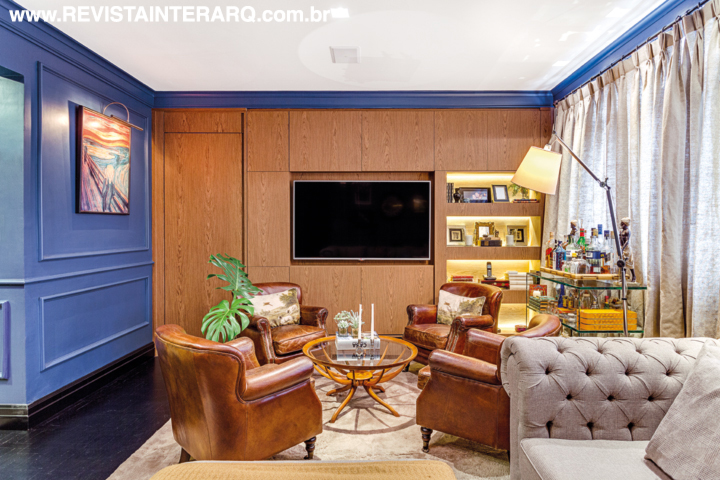 O espaço do home theater tem painel em freijó, poltronas de couro (Marizza Prado) e cortina em linhão. O tapete em lã de carneiro da By Kamy sobre o piso preto confere aconchego. 