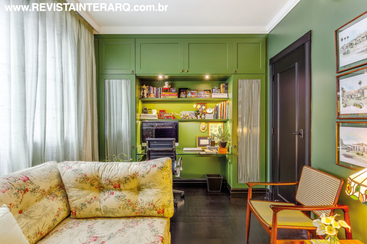 O office com mobiliário planejado em tom de verde também funciona como quarto de hóspedes. O banco em madeira e palhinha é da Jackie Móveis e o sofá-cama foi confeccionado pela Estofados Cardoso com tecido floral