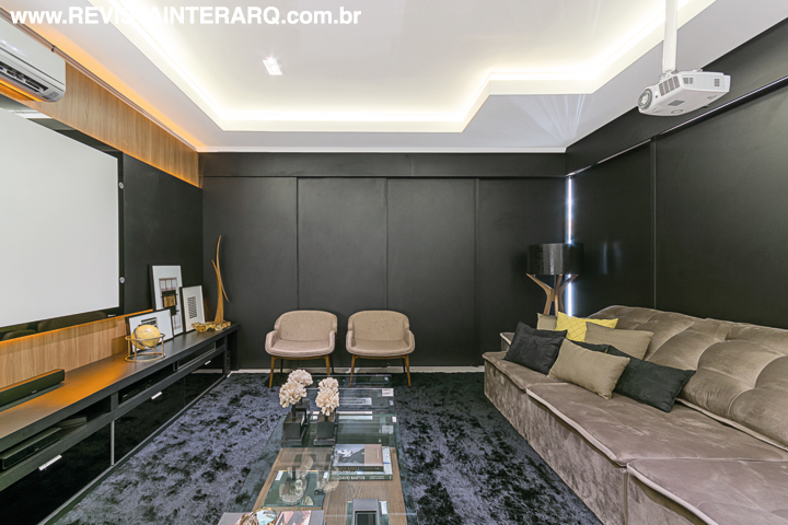 O home theater com móvel da Novo Conceito Móveis e estofados confortáveis pode ser totalmente integrado com a sala de jantar e a cozinha ou, na hora da sessão cinema, ser isolado por uma porta automatizada, que garante a acústica impecável