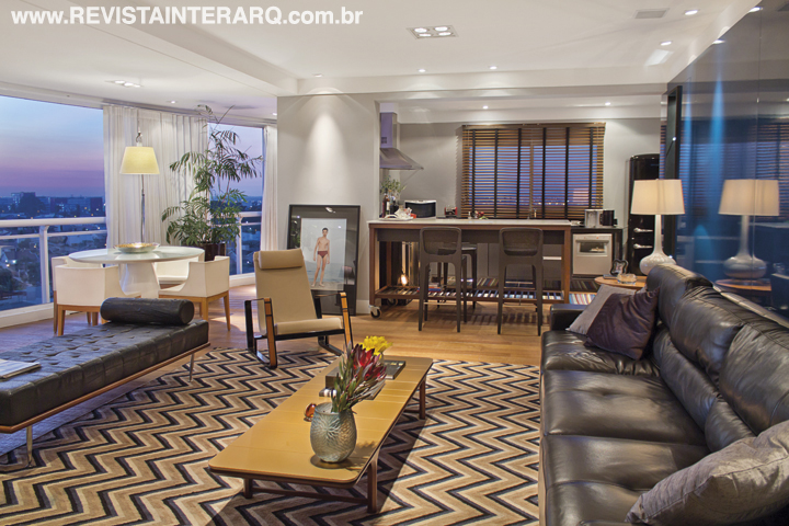 O balcão em estilo industrial une a cozinha ao amplo living, que se estendeu ao espaço da antiga varanda