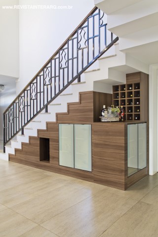 Detalhe do vão escada que leva ao home cinema, transformado em adega e bar graças à minuciosa marcenaria desenhada pelo arquiteto e executada pela Romanzza. O guarda-corpo de ferro é da Trimetal