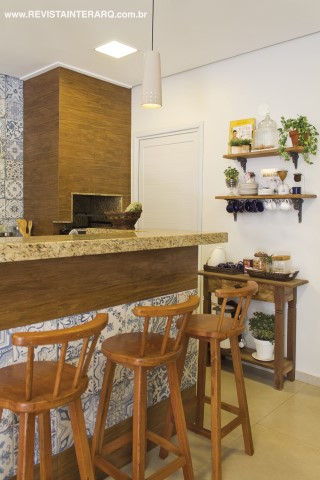 Na área gourmet, o charme ficou por conta da composição com porcelanato amadeirado e revestimento que lembra azulejos portugueses (tudo da Casa dos Construtores). Os móveis de madeira são do acervo da família