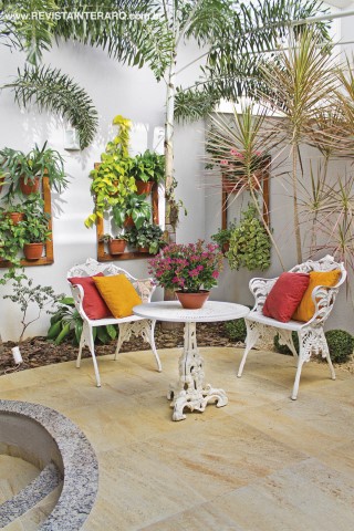 Um dos cantos de relaxamento, com piso de pedra (3D Telhas e Pedras) e jardins tropicais