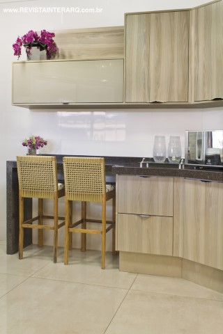 Para a cozinha, o arquiteto optou pela bancada em granito preto (Vidraçaria e Marmoraria Destak) e armários planejados (Todeschini) no mesmo tom suave do piso (Casa dos Construtores). As banquetas em fibras são da Espaço Fibras Decor Home